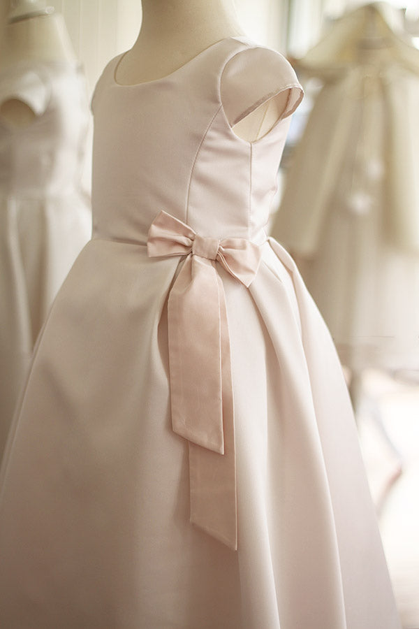 Robe longue de cérémonie fille en satin crème et noeud rose. Cousu main en France. Vue de côté.