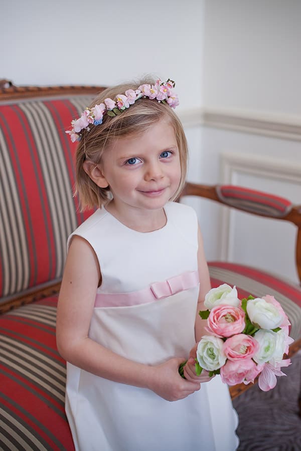 Robe trapèze cérémonie fille en coton blanc cassé et ruban rose. Photo du gros plan du noeud.