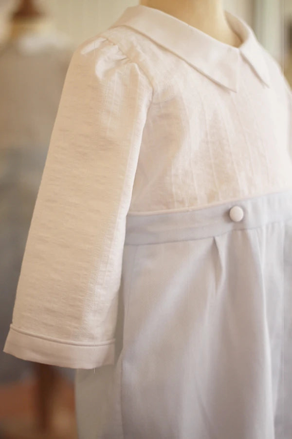 Barboteuse cérémonie bébé garçon Hugo. Corsage en coton brodé blanc. Pantalon en coton bleu ciel. Création française Fil de Légende. Photo des manches.