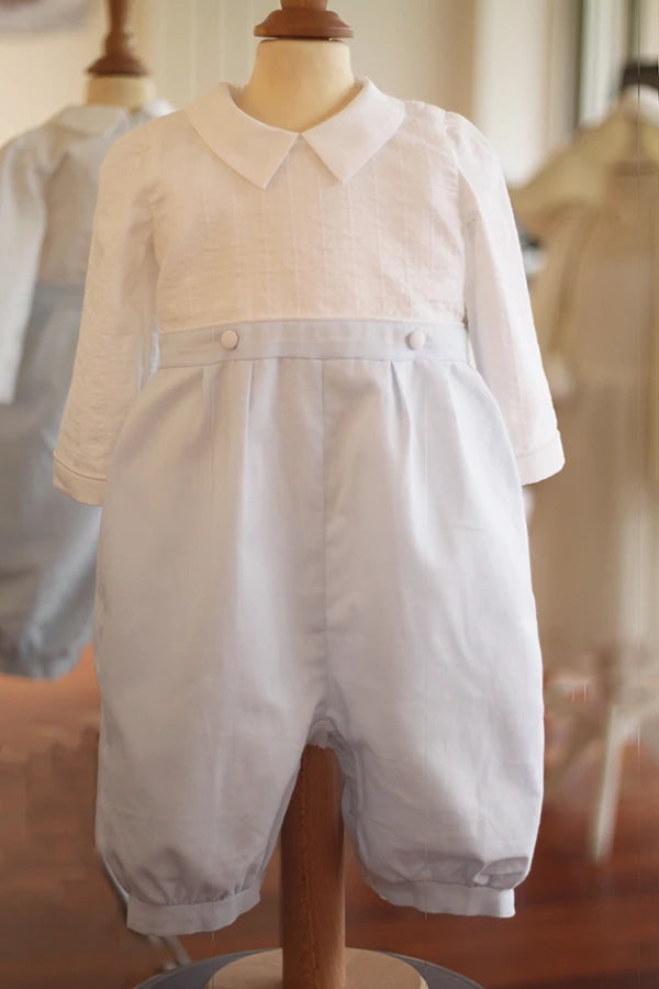 Barboteuse cérémonie bébé garçon Hugo. Corsage en coton brodé blanc. Pantalon en coton bleu ciel. Création française Fil de Légende. Disponible en ligne et en boutique à Paris, Neuilly-sur-Seine.