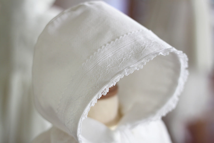 Bonnet de baptême bébé fille Angelina. Bonnet pour l'hiver en velours de coton et dentelle de Calais, doublé polaire. Création française Fil de Légende. Photo de la dentelle.