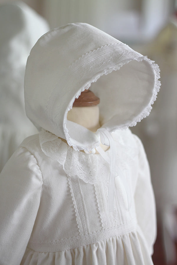 Bonnet de baptême bébé fille Angelina. Bonnet pour l'hiver en velours de coton et dentelle de Calais, doublé polaire. Création française Fil de Légende. Disponible en ligne ou en boutique à Paris, Neuilly-sur-Seine.