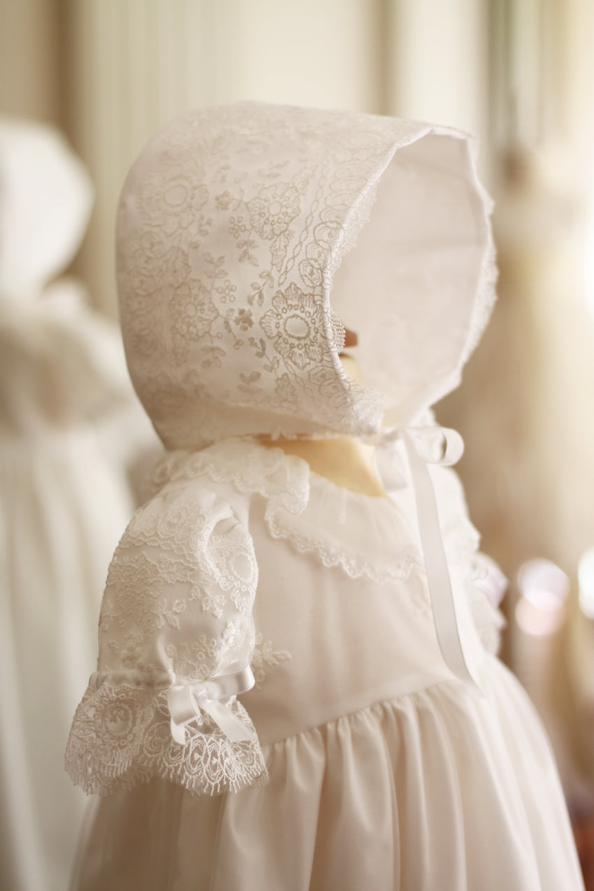 Bonnet de baptême bébé fille Sofia en tulle souple brodé italien blanc cassé, doublé de coton. Création française Fil de Légende. Disponible en ligne ou en boutique à Paris, Neuilly-sur-Seine.