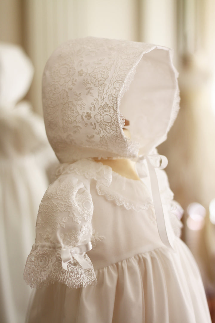 Bonnet de baptême bébé fille Sofia en tulle souple brodé italien blanc cassé, doublé de coton. Création française Fil de Légende. Disponible en ligne ou en boutique à Paris, Neuilly-sur-Seine.