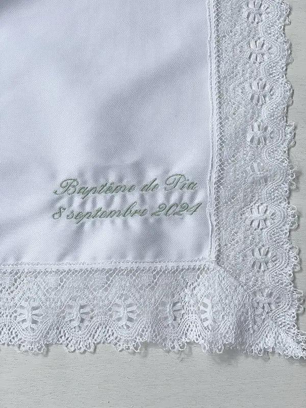 Broderies baptême prénom et date du baptême en fil vert sauge sur un châle de baptême. Boutique Fil de Légende à Paris, Neuilly-sur-Seine.