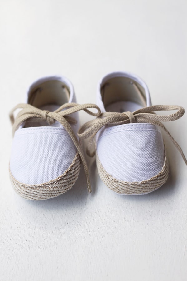 Chaussons espadrilles bébé pour cérémonie et baptême en toile blanche et lacets beiges. Magasin Fil de Légende Paris, Neuilly-sur-Seine.