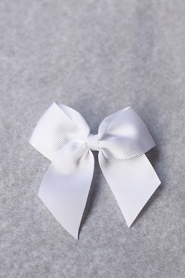 Pince cheveux noeud en gros grain blanc pour petite fille. Parfait pour sublimer une robe de cérémonie pour enfant. Boutique Fil de Légende à Paris, Neuilly-sur-Seine.