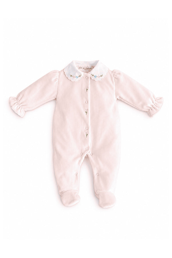 Pyjama bébé fille Eva en velours de coton rose pâle, avec col blanc brodé de fleurs roses et bleues, manches bouffantes et poignets à volants. Personnalisable avec l'initiale de bébé brodée en option – Fil de Légende.