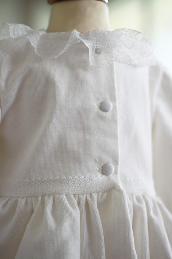 Robe de baptême fille pour l'hiver en velours blanc cassé et dentelle de Calais, doublée polaire. Création française Fil de Légende. Photo du dos de la robe.