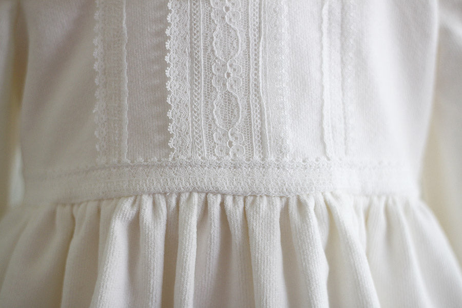 Robe de baptême fille pour l'hiver en velours blanc cassé et dentelle de Calais, doublée polaire. Création française Fil de Légende. Photo de la dentelle.